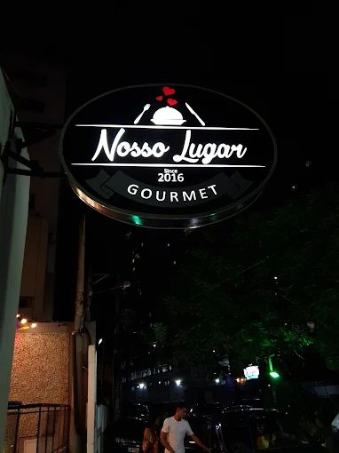 Letreiro iluminado do Nosso Lugar Gourmet, since 2016, à noite